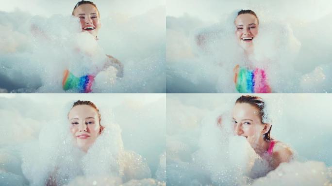 快乐美丽的女人快乐而轻松地覆盖着沐浴泡沫。慢动作