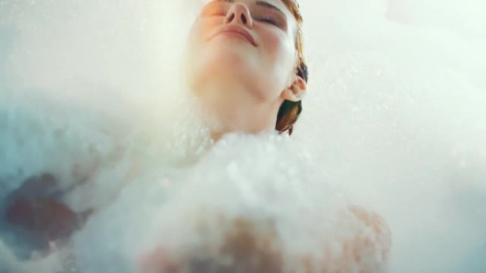 美丽的女人享受着沐浴泡沫的放松时光。慢动作