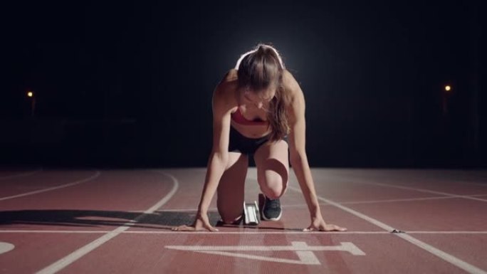 慢动作女赛跑者在体育场的黑暗中近距离特写职业赛跑者竞技