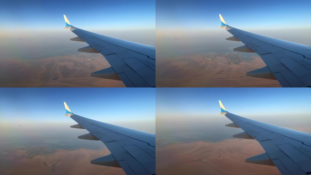 飞机机翼飞越海岸线和干旱的沙漠时光倒流