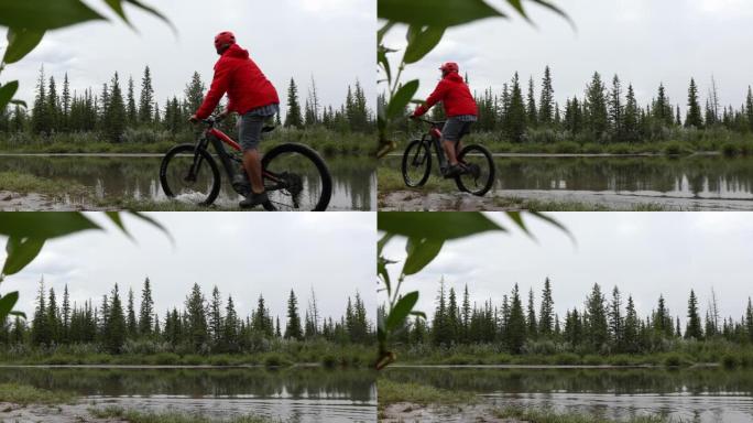 暴雨过后，男性山地自行车手穿越小溪边缘