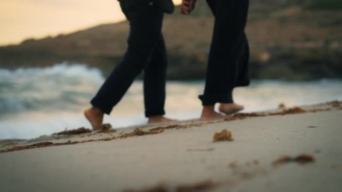 非洲族裔浪漫情侣人的脚走出大海，在海滩上行走