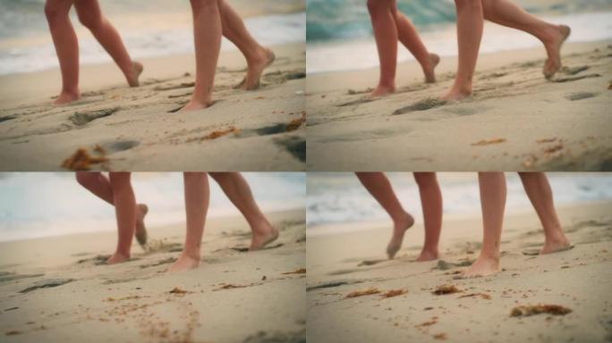 特写两个人的脚走出大海，在海滩上行走