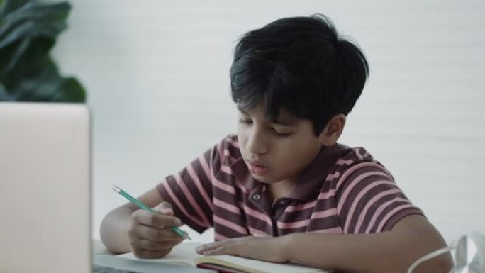 亚洲男孩在家中使用笔记本电脑进行在线学习