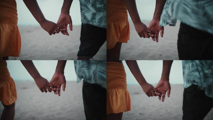 亲密亲密的非洲族裔夫妇牵手。一起在海滩上浪漫散步