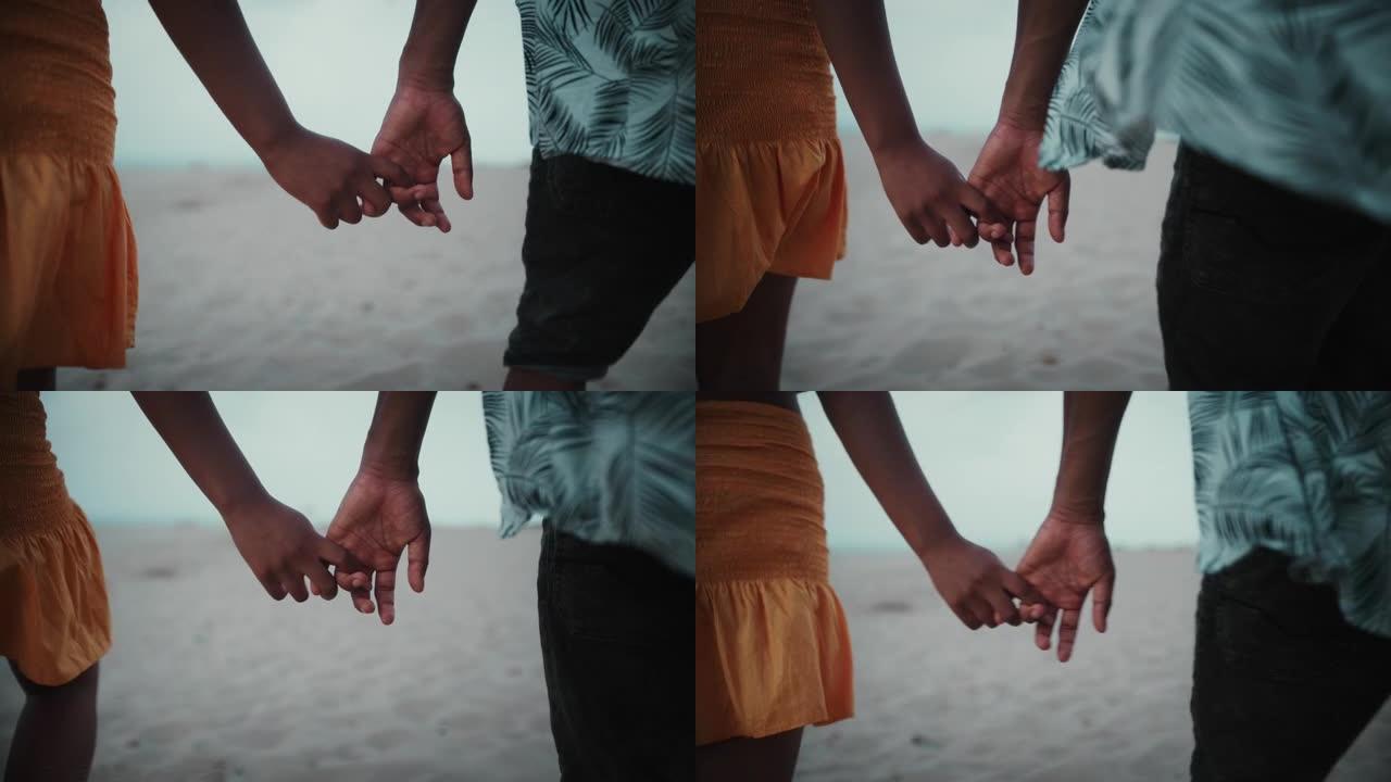 亲密亲密的非洲族裔夫妇牵手。一起在海滩上浪漫散步
