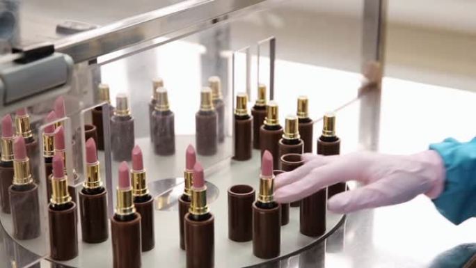 化妆品生产的过程。在化妆品厂工作的女人。口红的质量检查。