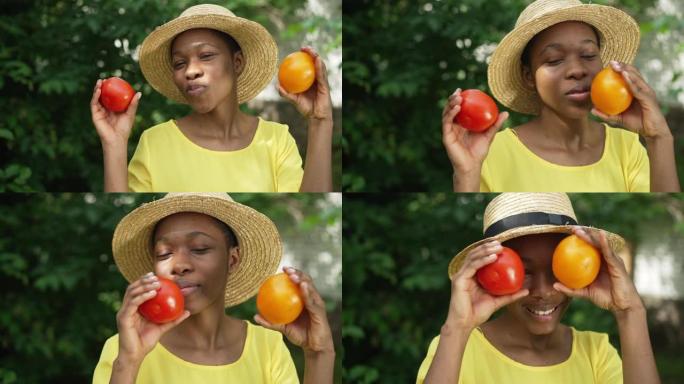 快乐的非洲裔美国女人开心地吹嘘看着相机的红色西红柿。快乐而自豪的年轻园丁的肖像在夏季秋天的日子里在户