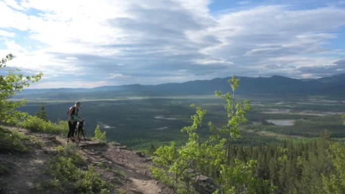 女人带着狗沿着山间小路走