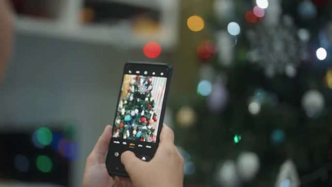 CU: 女人的手在家里拍圣诞树的照片