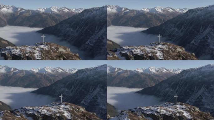 空中无人机在被山脉包围的山顶上拍摄十字架