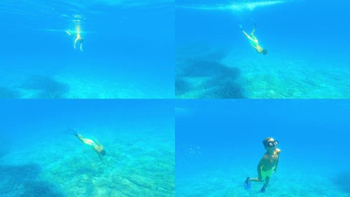男孩戴着潜水面具和脚蹼潜水到海底