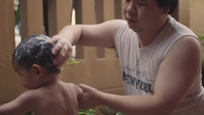 爸爸洗澡时给儿子洗头。