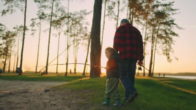 爷爷和孙子在日落时分一起在森林或自然公园散步，去河边钓鱼