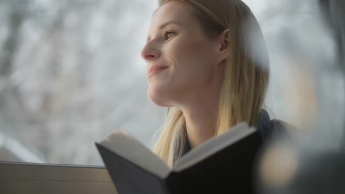 女人坐在窗台上，热情地看书