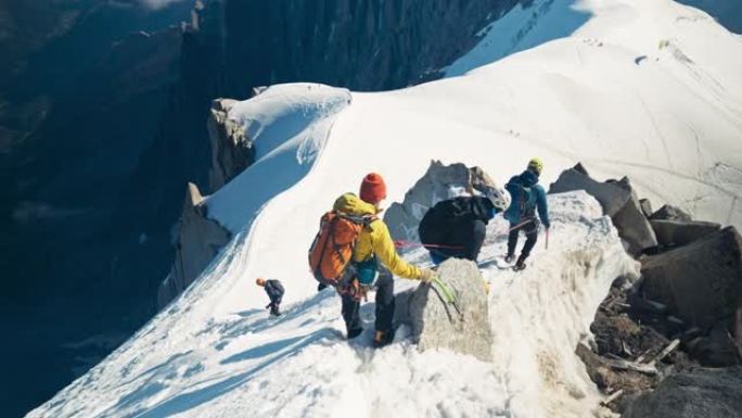 一队登山者在山顶上移动。冬季冒险。视点