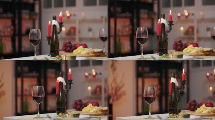 节日餐桌上有燃烧的蜡烛、葡萄酒和壮阳食物、浪漫晚餐