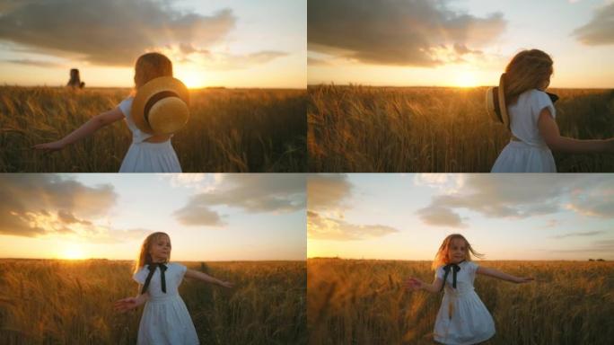 迷人的白色连衣裙小女孩在美丽如画的日落中在金色麦田上旋转