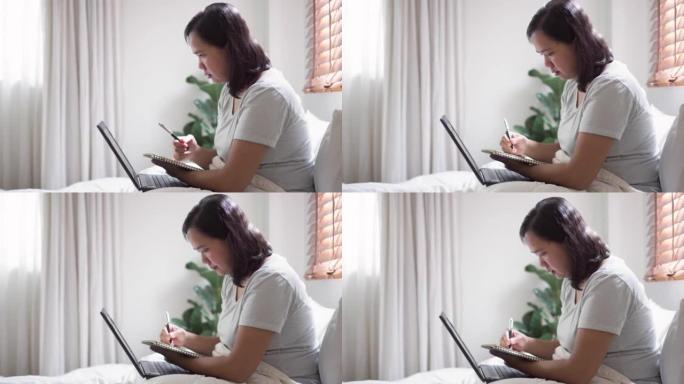 女人在家通过笔记本电脑上的在线教育进行自学