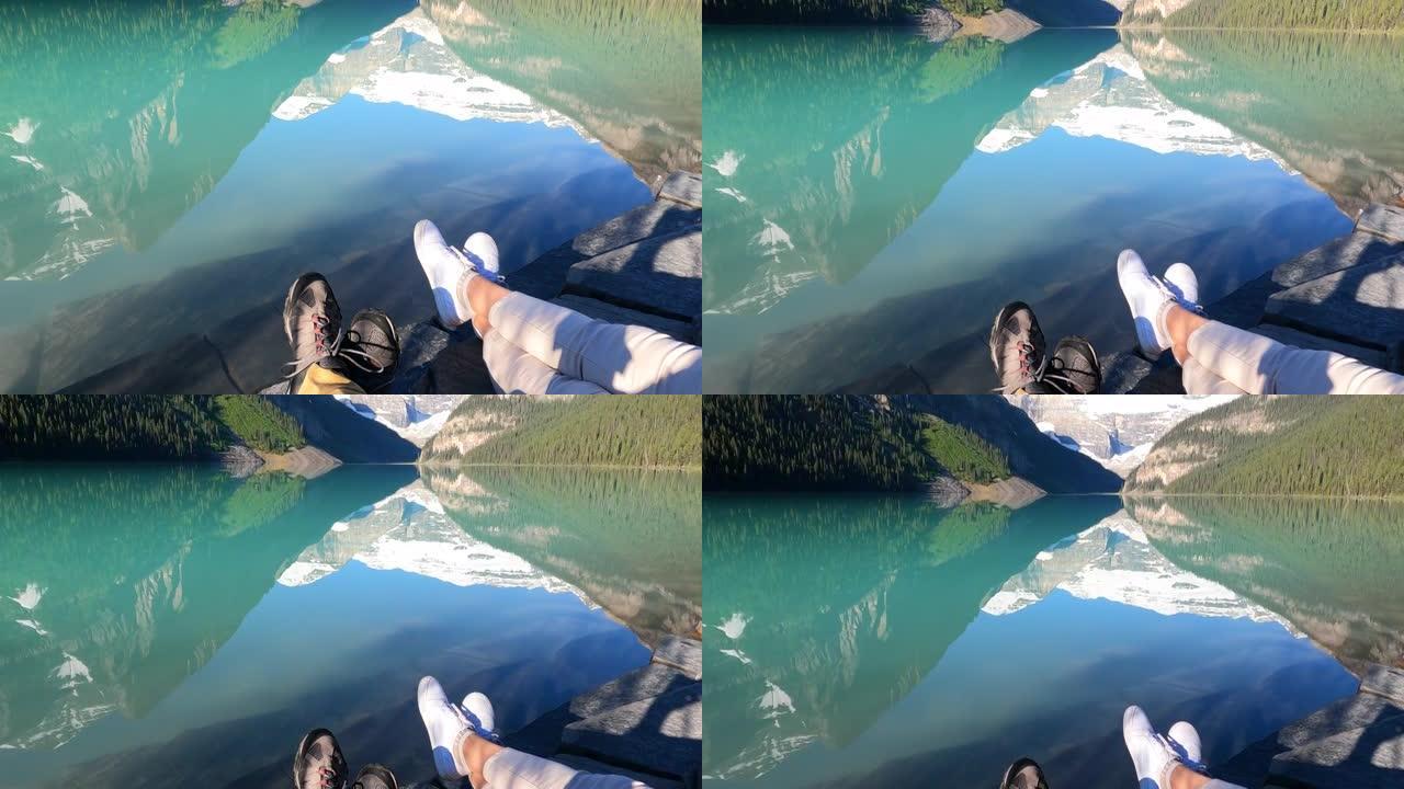 夫妇在湖岸山上放松，用智能手机拍照