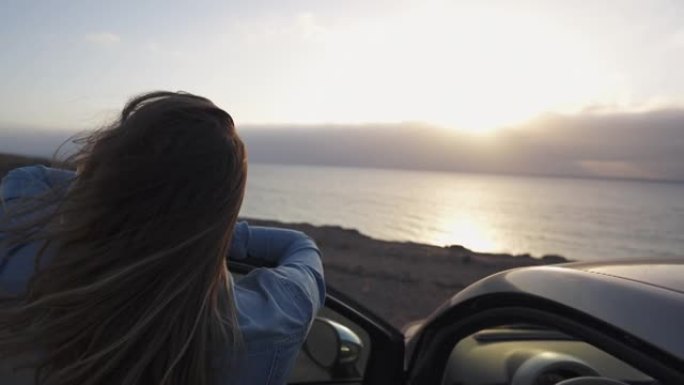 特写镜头，一名妇女在停车时从汽车上望向大海