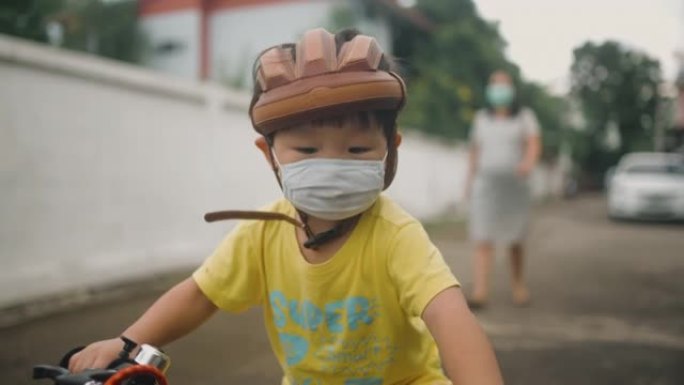 蹒跚学步的小男孩在户外骑自行车玩得开心