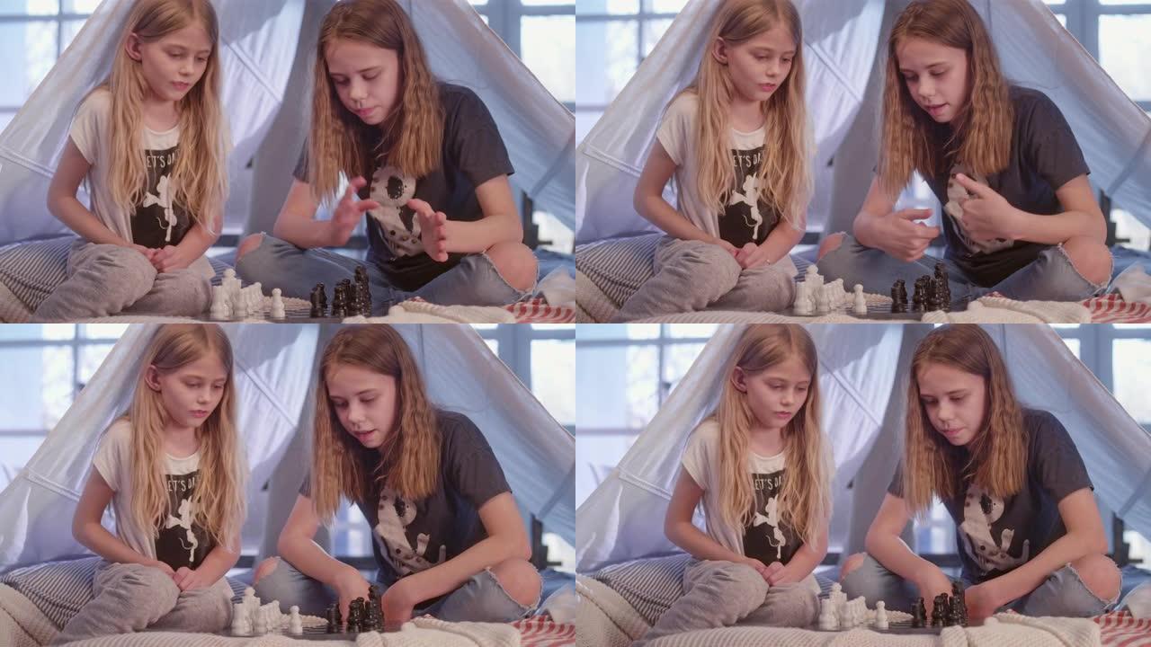两姐妹在舒适的天篷床上下棋。战略课程
