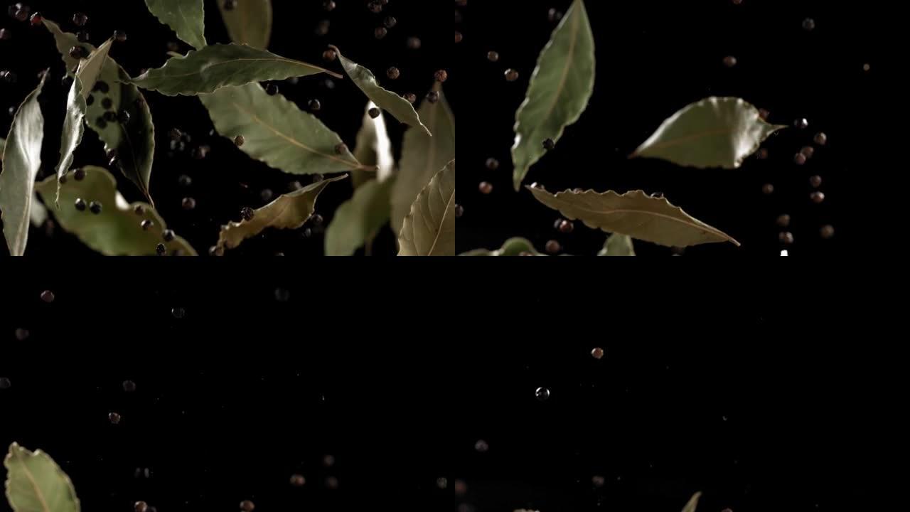 飞行混合香料月桂叶和黑胡椒在黑色背景的超级慢动作拍摄。