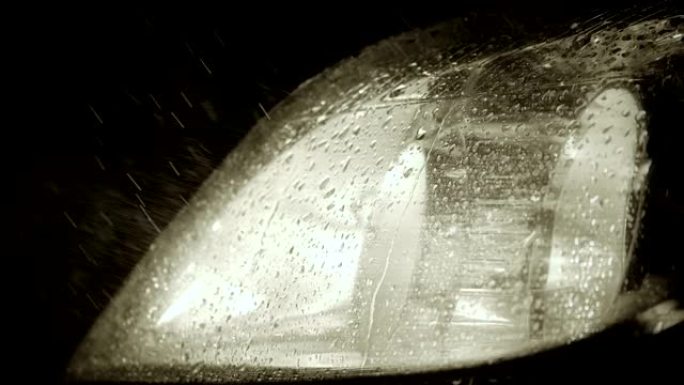 汽车前大灯光线中有雨滴和细水悬挂