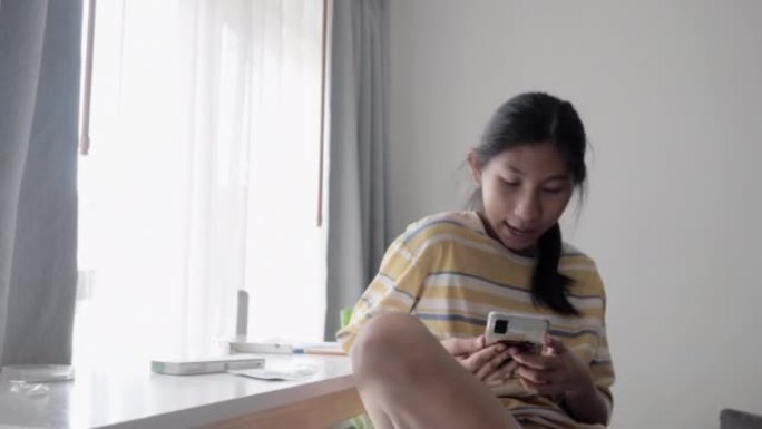亚洲女孩通过智能手机制作视频，用于在家中使用新型冠状病毒肺炎进行快速测试，然后在在线教室发送给她的老