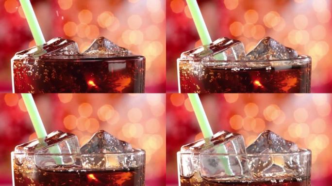 可乐和饮料管，在模糊的光线，模糊的背景下，在玻璃中带有冰和气泡。