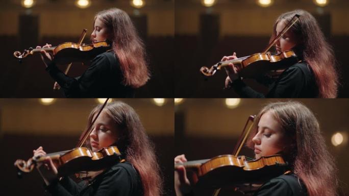 年轻女小提琴手在音乐厅练习拉小提琴女小提琴手肖像