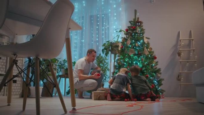 Samya父亲和两个儿子一起为新年和圣诞节装饰圣诞树。新年装饰品