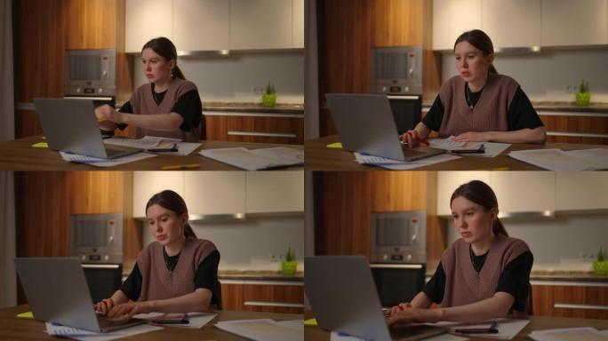 商业经济学家分析师说，一名妇女在家庭办公室里用笔记本电脑远程工作的肖像，并在图表上记录数据。写下做笔