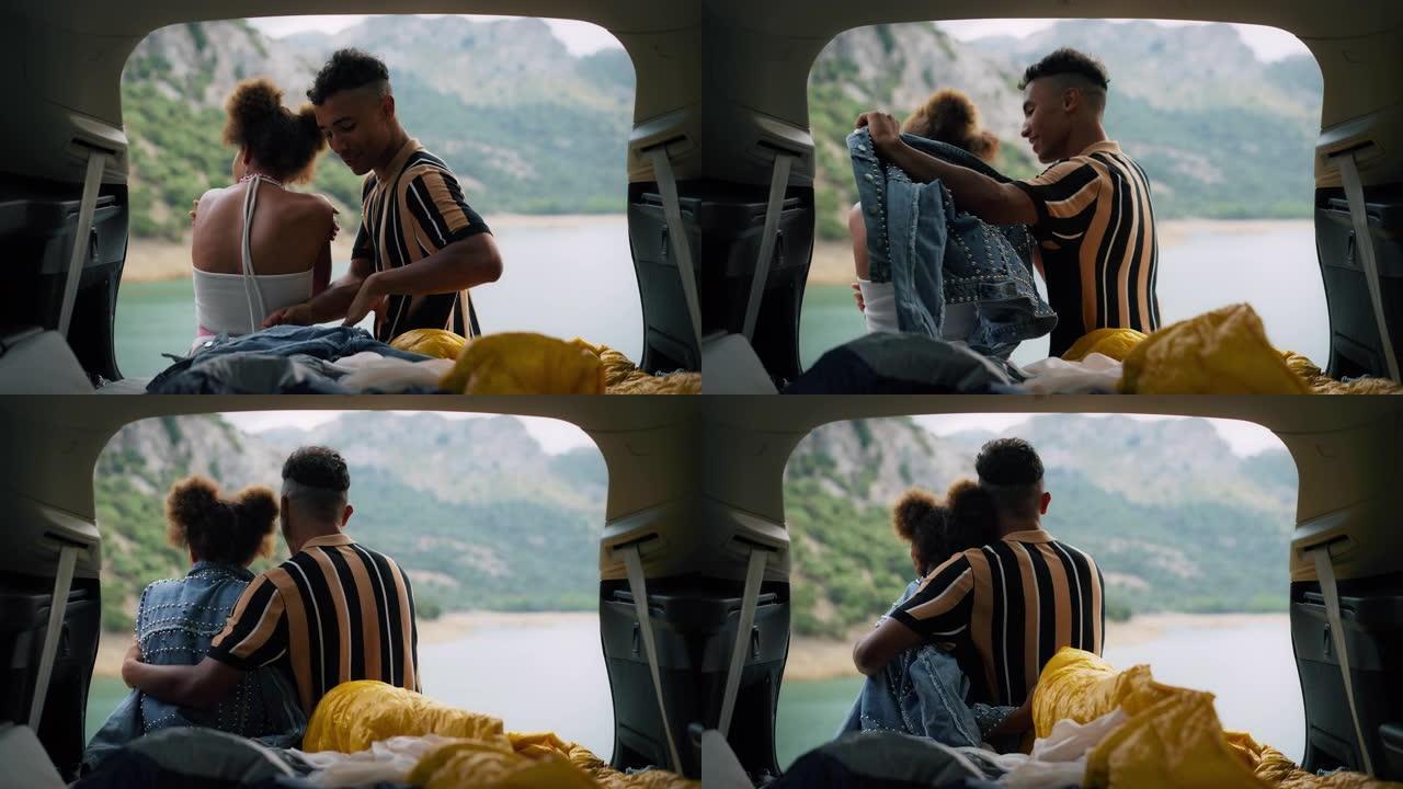 非洲族裔情侣坐在美丽的绿松石湖边的汽车里拥抱