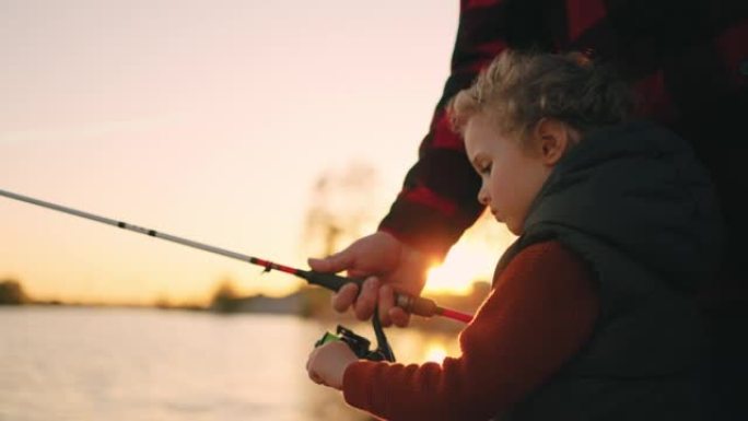 小男孩在大自然中与爸爸或爷爷共度周末，孩子在钓竿钓鱼
