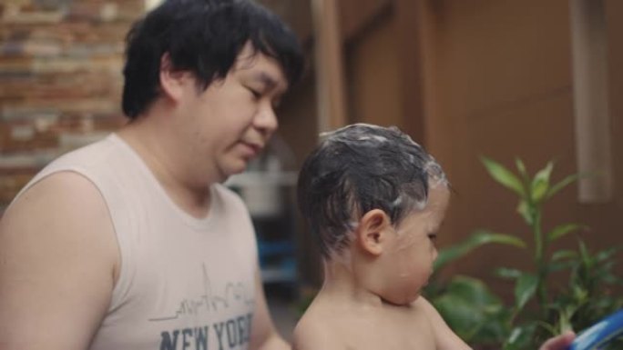 亚洲蹒跚学步的男孩在户外洗澡