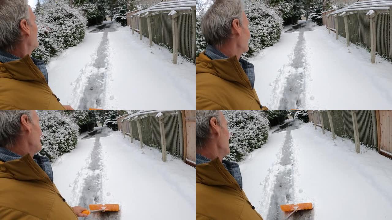 男子在漫长的车道上铲雪