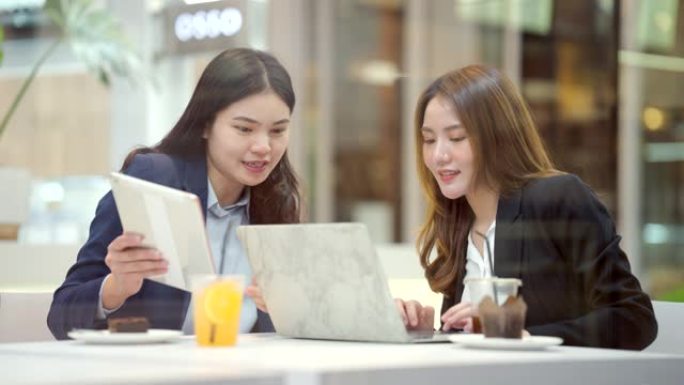 两位亚洲商界女性在网上讨论和购物。