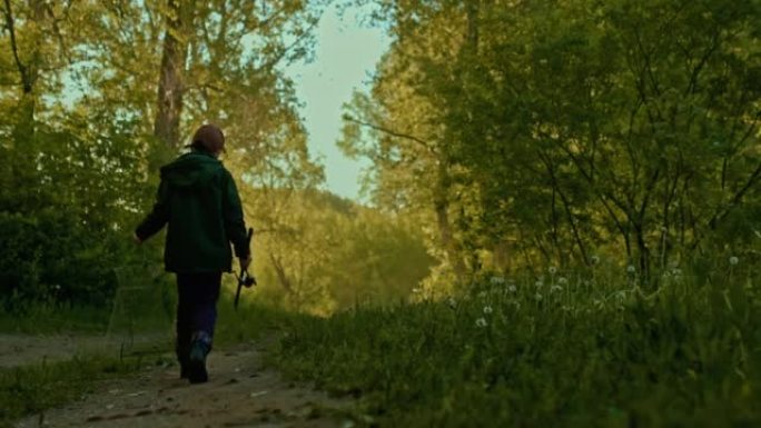十几岁的男孩穿得像渔夫独自走在美丽的森林，后视镜，4K, Prores