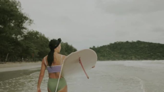 亚洲女性冲浪视频持有人冲浪板前冲浪