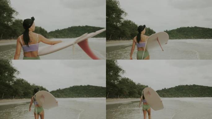亚洲女性冲浪视频持有人冲浪板前冲浪