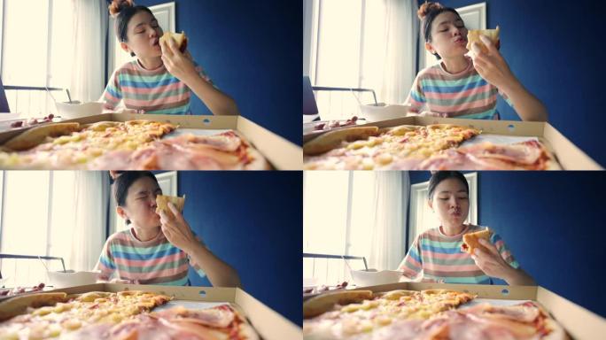 漂亮的年轻女子在家吃披萨。