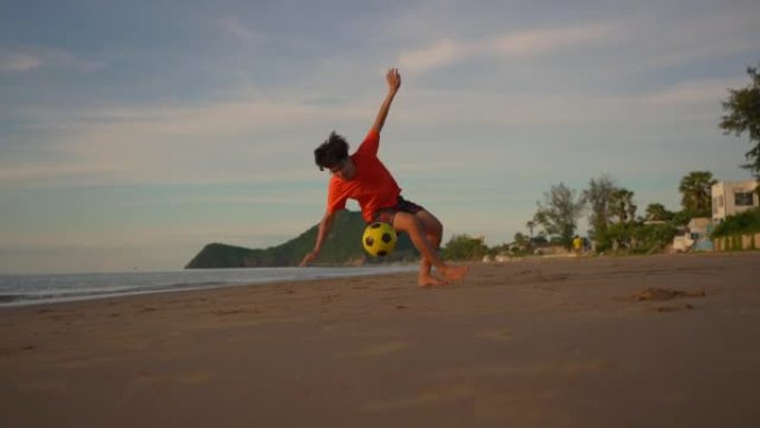 慢动作: 踢足球到海滩上的守门员
