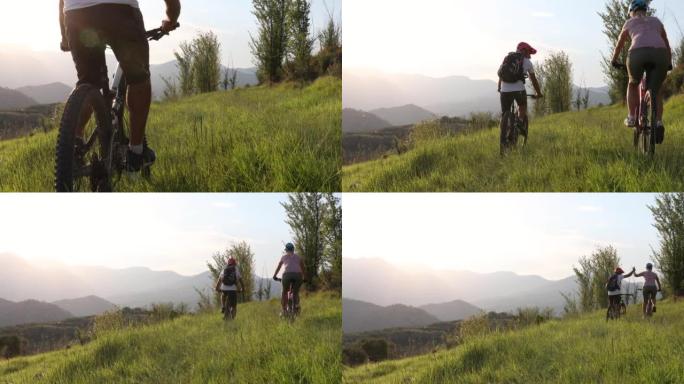 成熟的山地自行车情侣穿越绿山草地