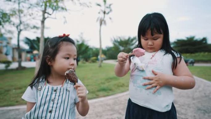 可爱的孩子在户外公园分享冰淇淋