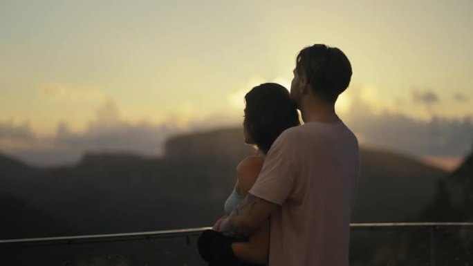 热爱游客的浪漫情侣拥抱在看日落的视点