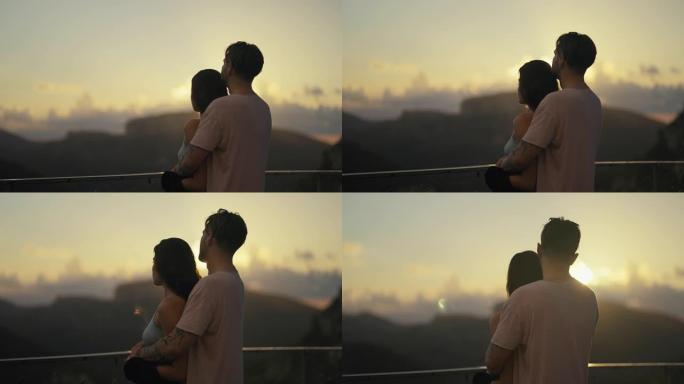 热爱游客的浪漫情侣拥抱在看日落的视点