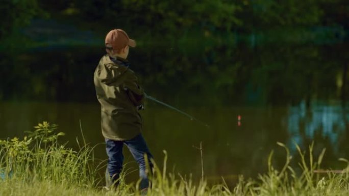 小男孩拿着鱼竿，看着池塘水面上的漂浮，抓鱼，4K，Prores