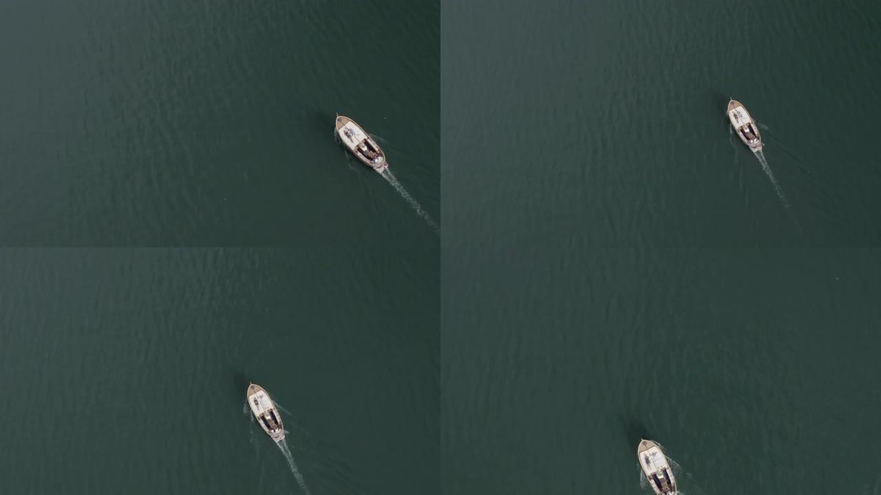 空中无人机在绿蓝水的湖上拍摄了一艘船